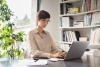 Young businesswoman sitting at her desk in the office and working on laptop.