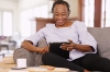 Woman sitting on sofa looking at tablet