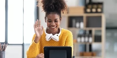 Person waving hello to someone on a zoom call