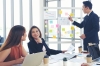 Group of workers meeting and reviewing flow charts